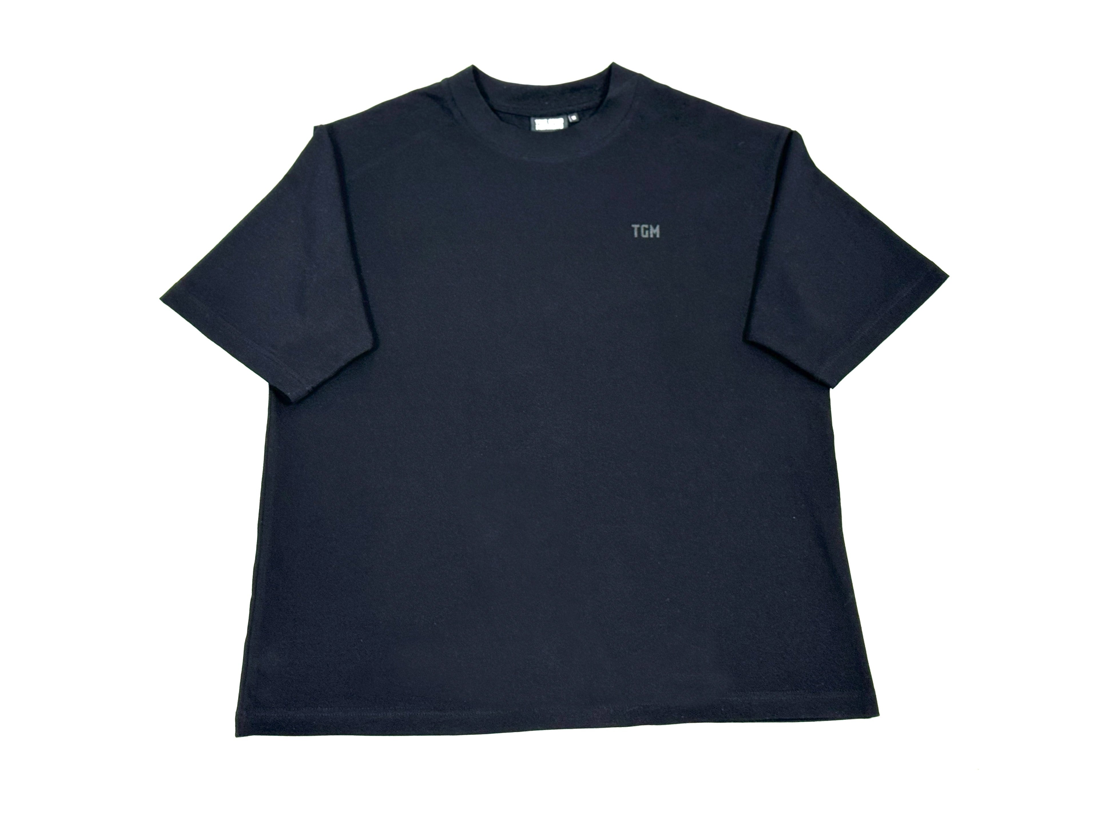 A black box fit T-Shirt with TGM logo on the left side of the shirt.