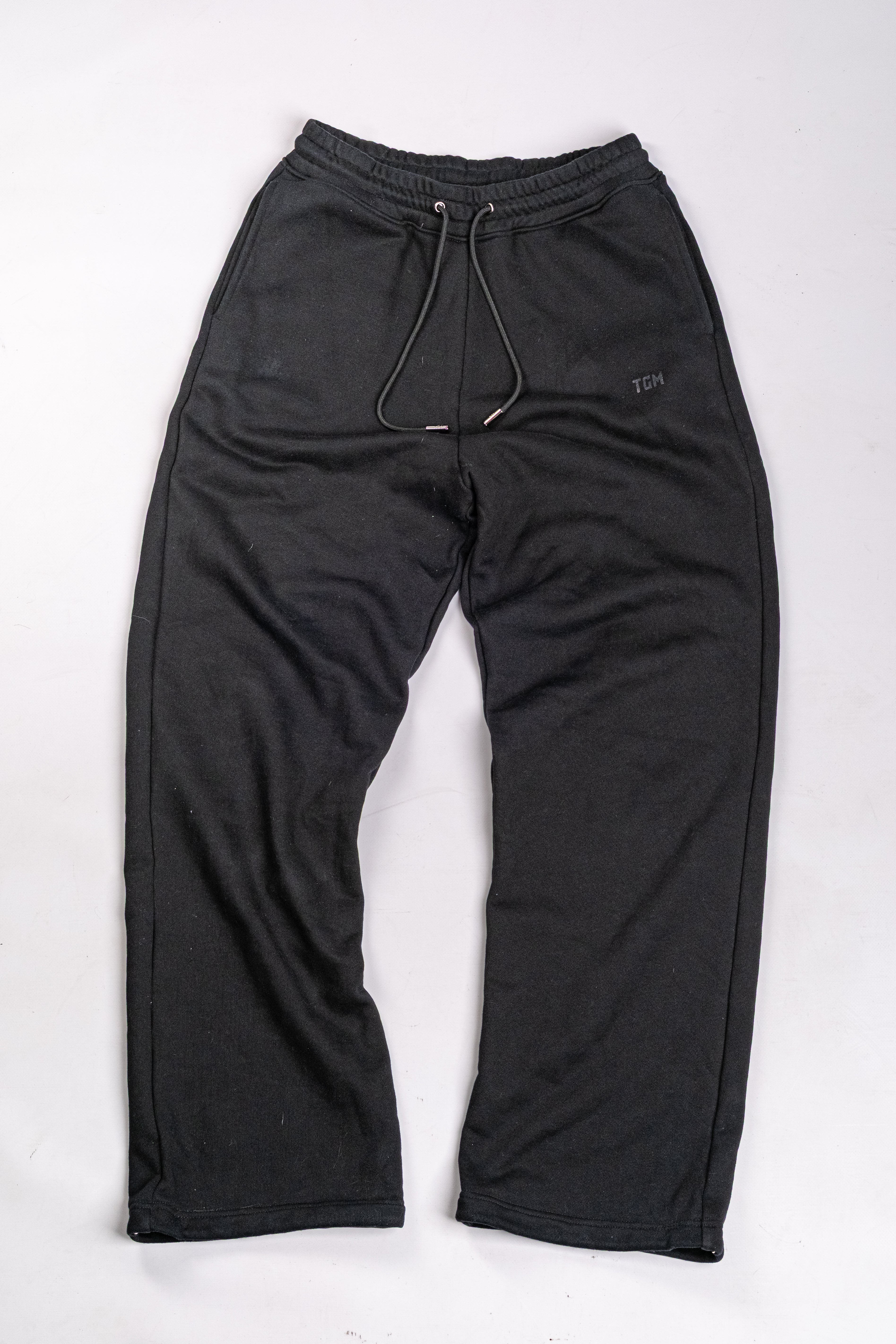 Black sweatpants with TGM logo on the left side of the leg 
